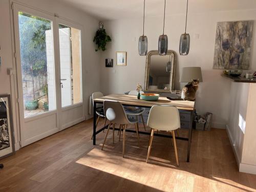 une salle à manger avec une table, des chaises et un miroir dans l'établissement Maison village provençal, à Éguilles