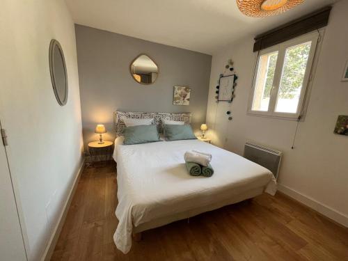 une chambre avec un lit avec des draps blancs et une fenêtre dans l'établissement Maison village provençal, à Éguilles