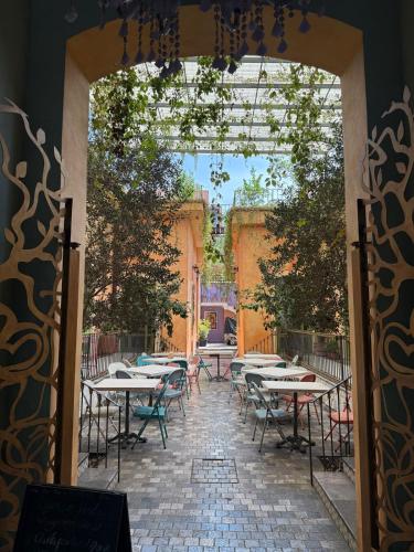 an open door to a patio with tables and chairs at Casa di Nina in Mexico City
