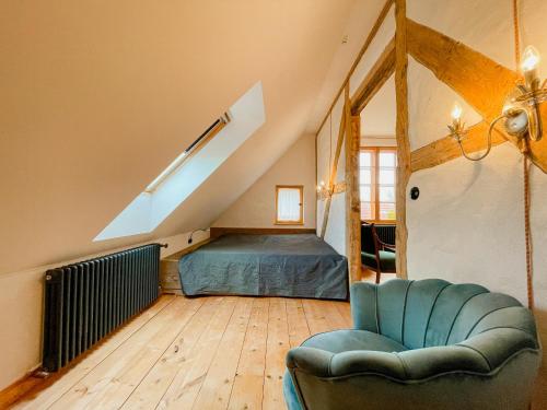 a bedroom with a bed and a chair in a attic at Cozy Holiday Apartment In The Manor House in Rambin