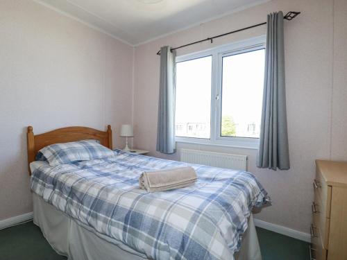 ein Schlafzimmer mit einem Bett mit einer blau-weißen Decke in der Unterkunft Lazy Days in Padstow