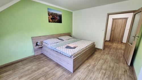 a bedroom with a bed in a room with green walls at Penzion a restaurace Zlatovláska u zámku Červená Lhota in Jižná