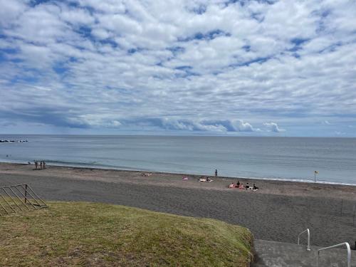 a beach with a group of people on the sand at Toes in the sand in São Roque