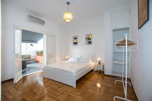 um quarto branco com uma cama e uma sala de estar em Athens Central Jacuzzi Retreat em Atenas