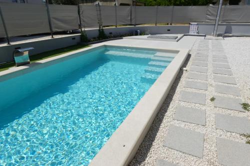 a swimming pool with blue water in a curb at PERISKA Home in Kaštela