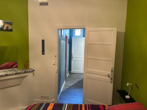 a hallway with a door and a room with green walls at maison de pêcheur in Fécamp