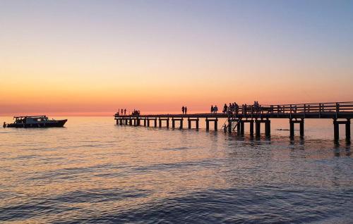 a pier with a boat in the water at sunset at Amazing Home In Munka-Ljungby With Wifi in Munka-Ljungby