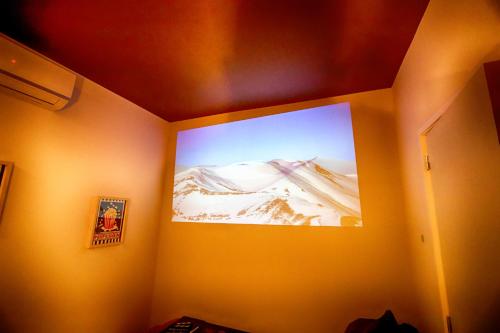 Cette chambre est dotée d'un grand écran mural. dans l'établissement Escapade en famille en appartement - Ciné privé, balnéo et jardin, à Saint-Ambroix