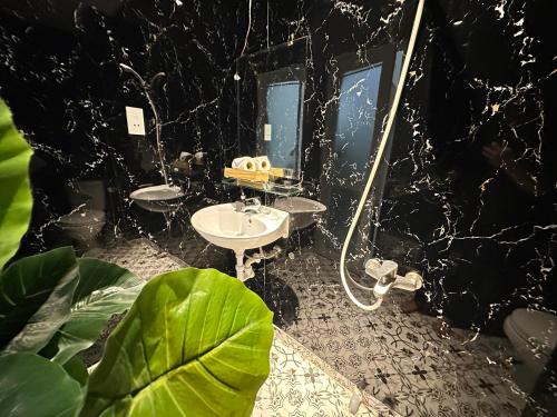 a black bathroom with two sinks and a mirror at Centana Hotel & Apartments in Ho Chi Minh City