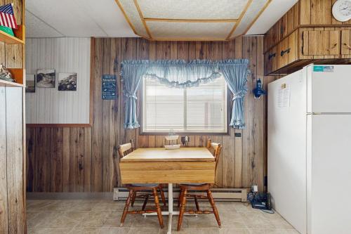 a kitchen with a table and a refrigerator at Scenic Bay Float Home Hideaway in Athol