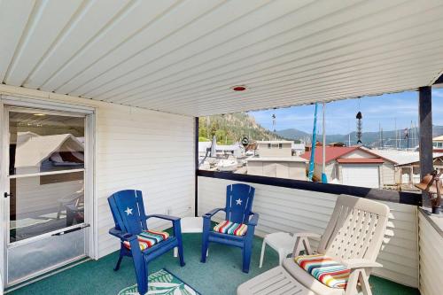 a porch with two chairs and a table and chairs at Scenic Bay Float Home Hideaway in Athol