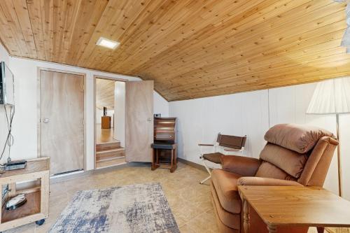 a living room with a couch and a wooden ceiling at Scenic Bay Float Home Hideaway in Athol