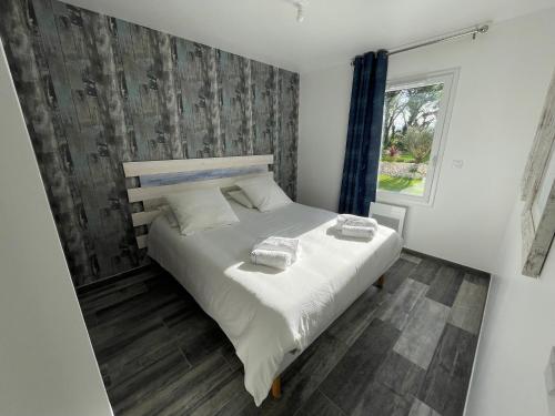 une chambre avec un lit avec deux serviettes dessus dans l'établissement Les rudali NewPort, à Chambon