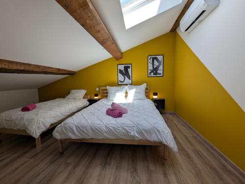deux lits dans une chambre aux murs jaunes dans l'établissement ColorChic 3 étoiles - Parking Privé Terrasse Clim - 120m2 Plein centre, à Mèze