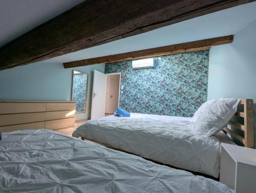 une chambre avec deux lits et un mur dans l'établissement ColorChic 3 étoiles - Parking Privé Terrasse Clim - 120m2 Plein centre, à Mèze