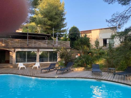 une piscine avec des chaises et une maison dans l'établissement Escapade en couple piscine privée, à Nages-et-Solorgues