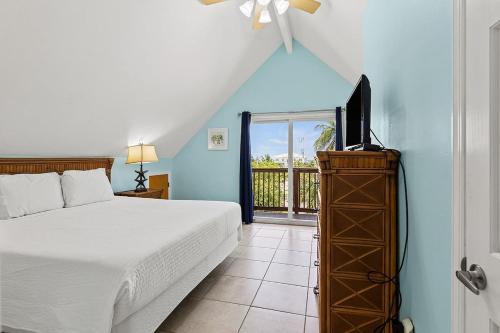 a bedroom with a bed and a flat screen tv at Kon Tiki - Waterfront Pool Home Near Sombrero Beach, 30' Dock, Tiki Hut in Marathon