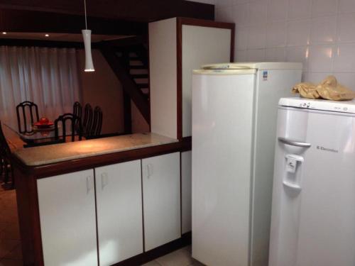 une cuisine avec un réfrigérateur blanc et un comptoir dans l'établissement Casa Marcos, à Capitólio