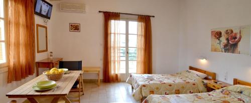 Habitación con 2 camas y mesa con fruta. en Villa Yiotevi, en Poros