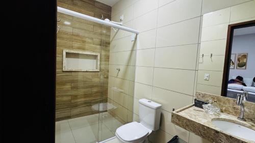 a bathroom with a toilet and a sink and a mirror at Casa da Serra Bananeiras in Bananeiras