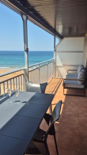 a balcony with a table and chairs and the ocean at Apto en 1ª linea de playa, Bakio in Bakio