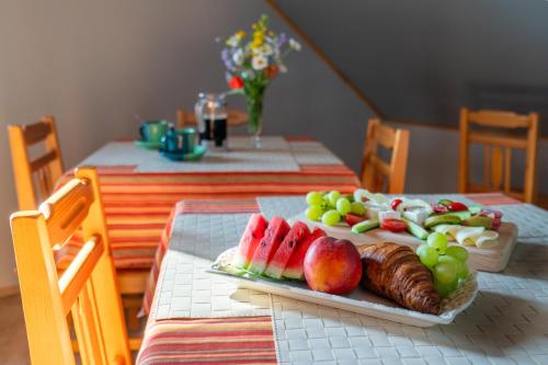 a plate of fruit on a table with a plate of food at Penzion Na Vyhlídce in Lukov