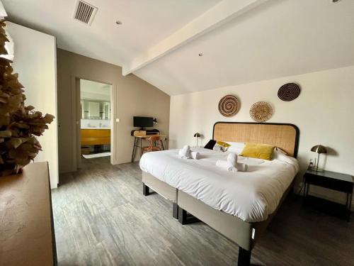 une chambre avec un grand lit blanc dans une pièce dans l'établissement Villa La Pignotte 2 min de la plage, à Gujan-Mestras