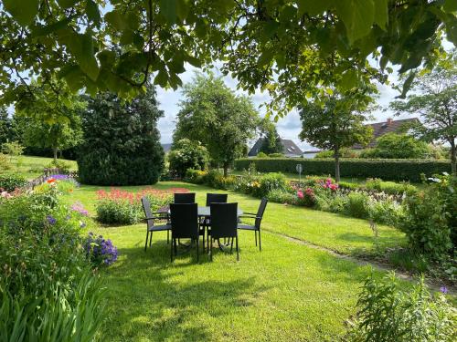 a table and chairs in a garden with flowers at Haus Dorfidyll in Rodershausen