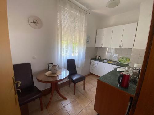 a kitchen with a table and a small table and chairs at Guest House Regina Mundi in Međugorje
