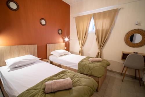 a hotel room with two beds and a mirror at Gemini in Laganas
