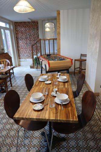 - une table en bois avec des chaises et un lit dans une chambre dans l'établissement Au Nid du MONT, à Le Mont-Saint-Adrien