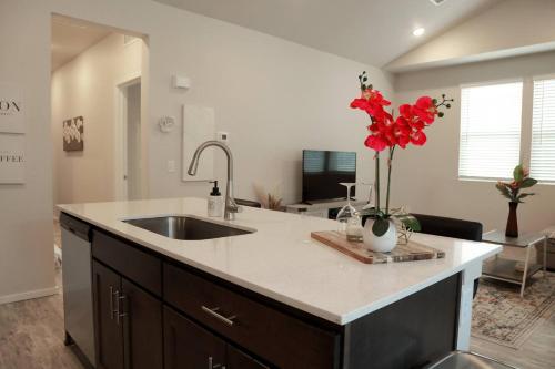a kitchen with a sink and red flowers on a counter at Lovely 2BR Home - Your Fort Collins Retreat! in Buckingham