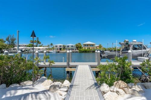 a dock with a boat in a marina at Off the Hook - Luxury Waterfront Pool Home, Kayaks & Bikes, 30' Dock in Marathon