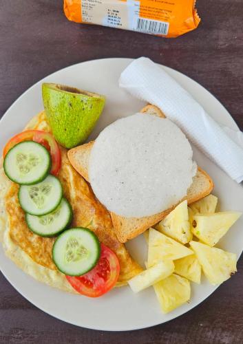 un piatto di cibo con una frittata con pomodori e cetrioli di Turtles Bay ad Arugam