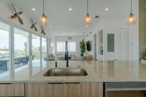 a kitchen with a sink and a living room at Paraiso Del Mar - Luxury Waterfront Pool Home, 65' Dock in Marathon