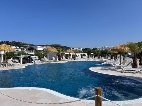 een groot zwembad met stoelen en parasols bij Villa Ialillo in Peschici