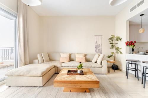 a living room with a couch and a coffee table at WabiSabi 2BR Stay Walk to Ferrari & Warner Bros in Abu Dhabi