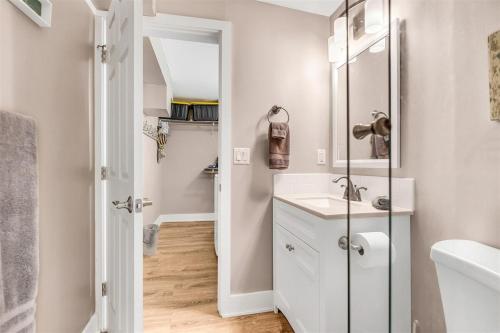 a white bathroom with a sink and a mirror at Reel Deal - Waterfront Pool Home, 76' Dock in Marathon