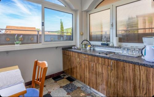a kitchen with a sink and two windows at Villa Ana Selce s bazenom i panoramskim pogledom na more in Selce