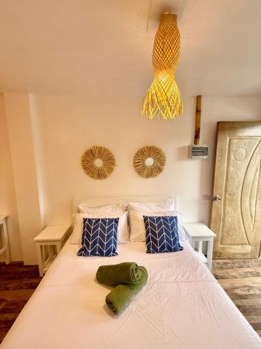 a bedroom with a bed with two towels on it at Utopia Port Barton in San Vicente