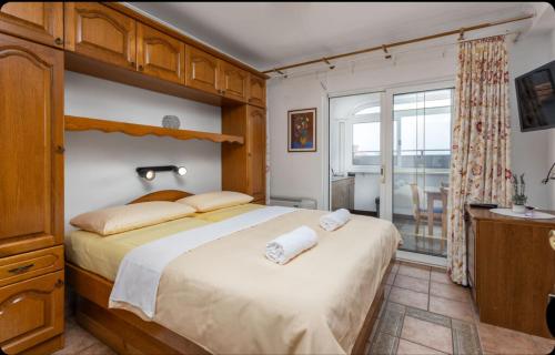 a bedroom with a large bed and a balcony at Villa Ana Selce s bazenom i panoramskim pogledom na more in Selce