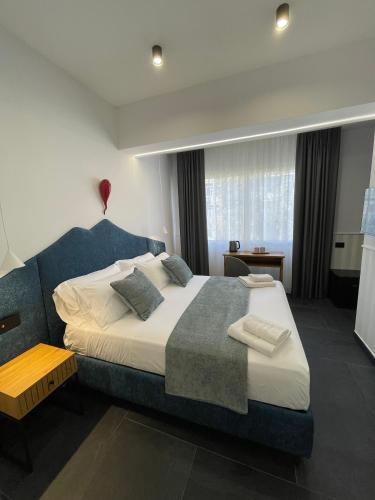 a bedroom with a large bed with a blue headboard at vesuvius115 in Naples