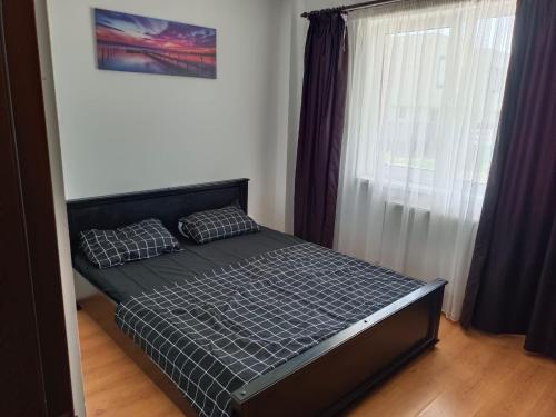 a small bed in a room with a window at Apartament Tiana in Mamaia Nord