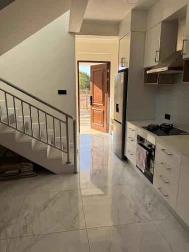 eine Küche mit einer Treppe, die zu einer Tür führt in der Unterkunft 2 Bed Forest Reserve & Gated community in Lusaka