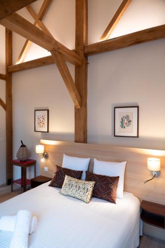- une chambre avec un grand lit blanc et des poutres en bois dans l'établissement 6 - Seigneurie Fouquet - Cocagne, au Palais