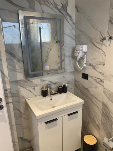 un bagno con lavandino bianco e specchio di Villa Dior a Sarandë