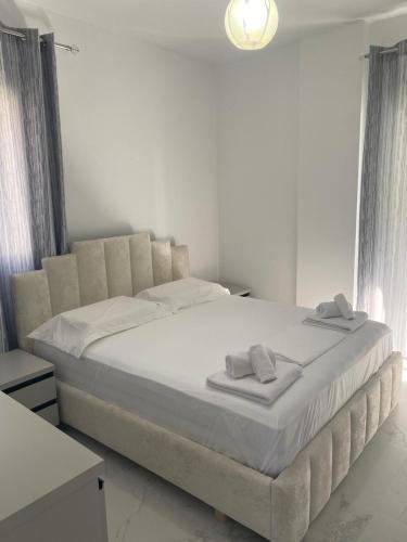 una camera da letto con un grande letto con lenzuola bianche di Villa Dior a Sarandë
