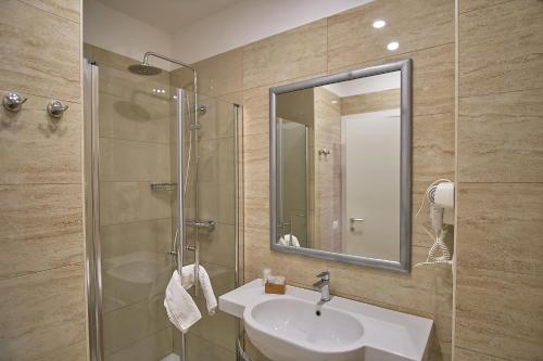 a bathroom with a sink and a shower with a mirror at Museum Guest House in Civitavecchia