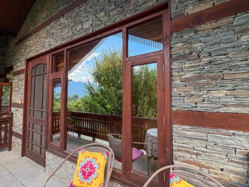 a sliding glass door on a stone building with a patio at Shivadya - A Luxury Boutique Experience in Manāli