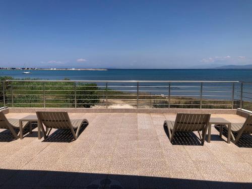 two benches and a table with a view of the ocean at TSABAS BEACH SIDE APARTMENTS ΤΣΑΜΠΑΣ ΠΑΡΑΛΙΑΚΑ Διαμερίσματα 4 in Kyllini